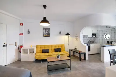 a living room with a yellow couch and a table at T1 Marques in Albufeira