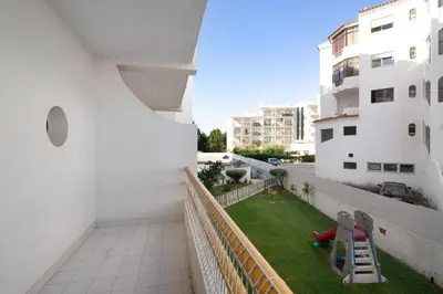 a balcony of a building with a small yard at Apartamento T1 Antonio Henriques in Albufeira
