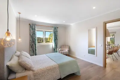 a bedroom with a bed and a table and chairs at Casa no Campo com vista mar in Loulé