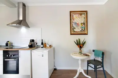 a kitchen with a small table and a white refrigerator at Casa no Campo com vista mar in Loulé