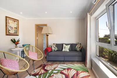 a living room with a couch and chairs and a window at Casa no Campo com vista mar in Loulé
