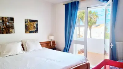 a bedroom with a bed and a sliding glass door at Praia da Galé, 250m da Praia e Piscina in Galé
