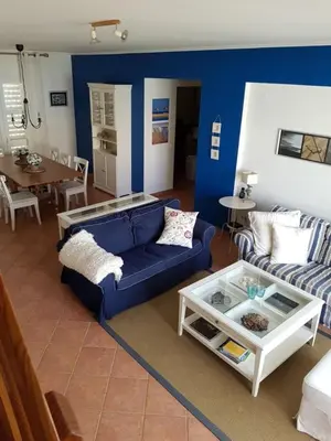 a living room with blue walls and a blue couch at Praia da Galé, 250m da Praia e Piscina in Galé