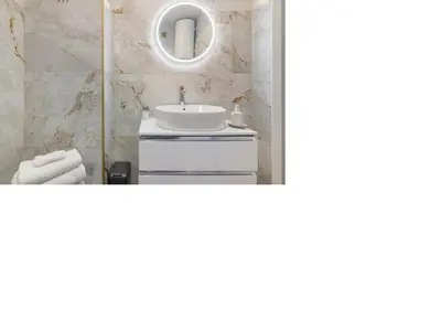 a white kitchen with a white table and chairs at Apartamento SUN7SET in Quarteira