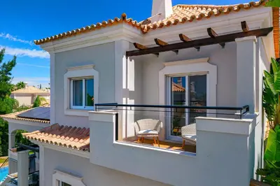 a white house with two chairs on a balcony at Villa Simone in Almancil