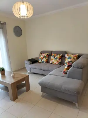 a living room with a couch and a coffee table at T2 Infante Moderno Wi-Fi Garagem 50 M Praia in Quarteira
