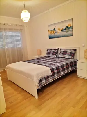 a bedroom with a bed and a window at T2 Infante Moderno Wi-Fi Garagem 50 M Praia in Quarteira