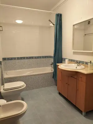 a bathroom with a toilet and a tub and a sink at T2 Infante Moderno Wi-Fi Garagem 50 M Praia in Quarteira
