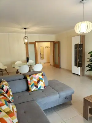 a living room with a couch and a table at T2 Infante Moderno Wi-Fi Garagem 50 M Praia in Quarteira