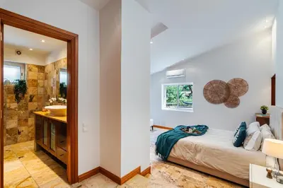 a bedroom with a bed and a bathroom with a sink at Villa Sea, Sun and Golf in Vilamoura in Quarteira