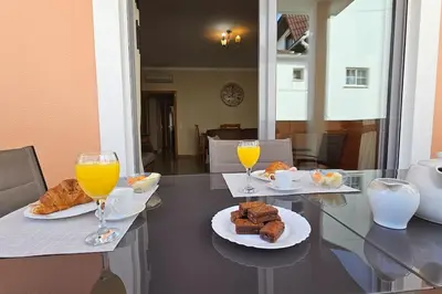 a table with two glasses of orange juice and pastries at D'Água Brisa beachside apartment in Albufeira