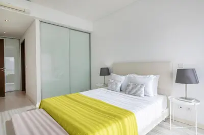 an apartment building with palm trees and a fountain at Quarteira Beach & Family Stay | Cavalo Preto in Quarteira