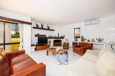 a kitchen with white cabinets and black appliances at Villa Veiguinha in Galé