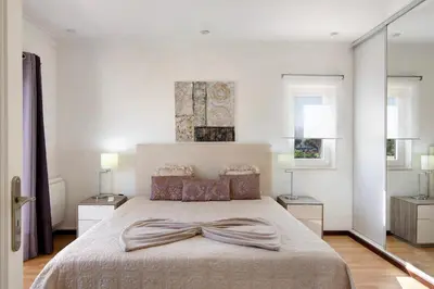 a bedroom with a bed and a large window at Vila Alonzo in Albufeira