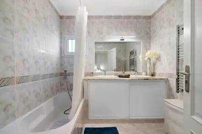 a bathroom with a tub and a sink at Vila Alonzo in Albufeira