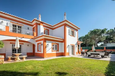 an orange and white house with a yard at Private Villa Ribeiro I Heated Pool, 4 Bed, BBQ, AC, WIFI, BEACH in Albufeira