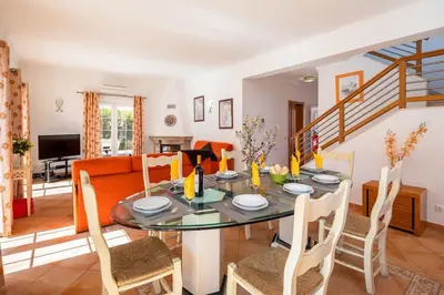 a dining room with a table with chairs and a couch at Private Villa Ribeiro I Heated Pool, 4 Bed, BBQ, AC, WIFI, BEACH in Albufeira