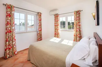 a bedroom with a bed and two windows at 4 Bed Private Villa Ribeiro II with heated pool, garden, wi-fi in Albufeira