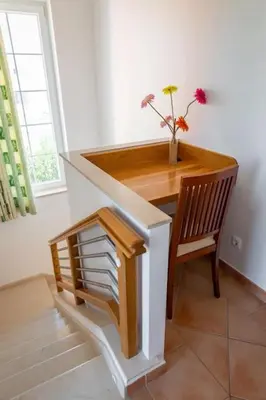 a desk with a vase of flowers on top of it at 4 Bed Private Villa Ribeiro II with heated pool, garden, wi-fi in Albufeira