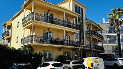 a yellow building with cars parked in front of it at Bicos 7 by Check-in Portugal in Albufeira