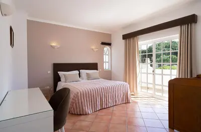 a bedroom with a bed and a large window at VTII & VTI 2 X Private Villas with pool and garden in Albufeira