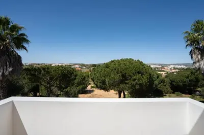 a white wall with trees in the background at VTII & VTI 2 X Private Villas with pool and garden in Albufeira