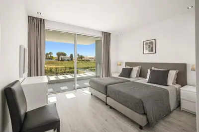 a bedroom with a bed and a chair and a window at Villa Casa Lirio by Villa Plus in Galé