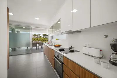 a kitchen with white cabinets and a counter top at Villa Casa Lirio by Villa Plus in Galé