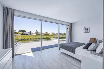 a bedroom with a bed and a large glass window at Villa Casa Magnolia by Villa Plus in Galé