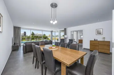 a dining room with a wooden table and chairs at Villa Casa Magnolia by Villa Plus in Galé
