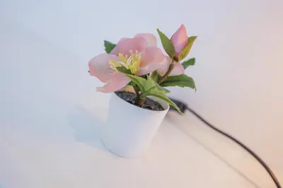 a white vase with a pink flower in it at Terracos de Quarteira 2 Red by Real Properties in Quarteira