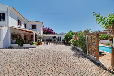 a house with a swimming pool and a fence at Quinta Grande de Boliqueime by Portucasa in Boliqueime