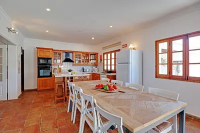 a kitchen with a large wooden table and white appliances at Quinta Grande de Boliqueime by Portucasa in Boliqueime