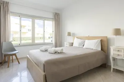 a bedroom with a large bed with two towels on it at Terracos Falesia II - Terrace with pool by HD in Vilamoura