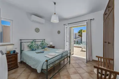 a bedroom with a bed and a door to a balcony at Villa Algarhb by Villa Plus in Albufeira