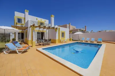 a villa with a swimming pool in front of a house at Villa Algarhb by Villa Plus in Albufeira