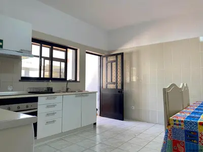 a kitchen with white cabinets and a table in it at Blife Aerya private rooms - Airport stay in Faro