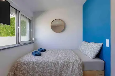 a bedroom with a bed with a mirror and a window at Cozy studio near the beach in Quarteira