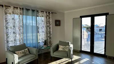 a living room with two chairs and a sliding glass door at Mourisca by Check-in Portugal in Vilamoura
