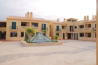 a building with a fountain in the middle of a courtyard at Vila Bairos Apartment Vilamoura in Vilamoura