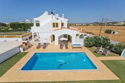a villa with a swimming pool in front of a house at Villa Carlos by Villa Plus in Galé