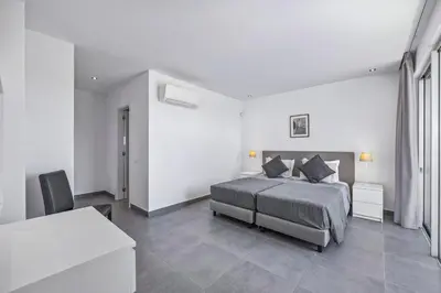 a bedroom with a bed and a desk and a table at Villa Casa Gardenia by Villa Plus in Galé