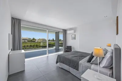 a bedroom with a bed and a large window at Villa Casa Gardenia by Villa Plus in Galé