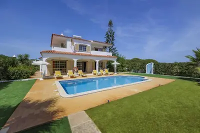 a villa with a swimming pool in front of a house at Villa Casa Lourenco by Villa Plus in Albufeira