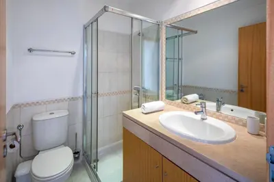 a bathroom with a toilet and a sink and a shower at Appartement Vista das ondas in Olhos de Água