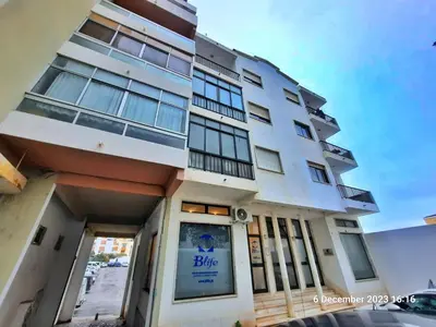 a white building with a blue sign on it at Blife Anya private rooms in Faro