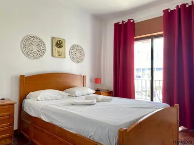 a bedroom with a large bed with red curtains at Blife Anya private rooms in Faro