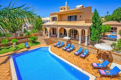 a villa with a swimming pool in front of a house at Villa Karlia by Villa Plus in Galé