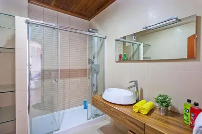 a bathroom with a shower and a sink and a mirror at Villa Karlia by Villa Plus in Galé
