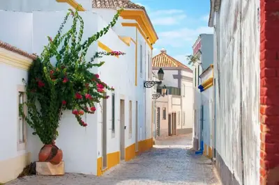 a narrow street in a town with white buildings at Blife Chelsya private rooms in Faro